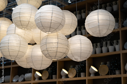 Many paper lanterns. Lighted paper lanterns inside of building, decoration