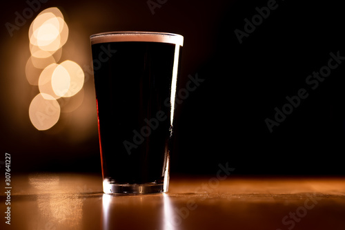 Pint of Dark Stout Beer on a Wooden Table with Copy Space