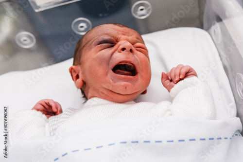 niño en incubadora recién nacido, bebé de un día llorando en el hospital.