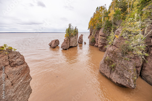 The rising tide of Bay of Fundy cover the ocean floor and isolate the flowerpot formations at Hopewell Rocks Park, New Brunswick, Canada