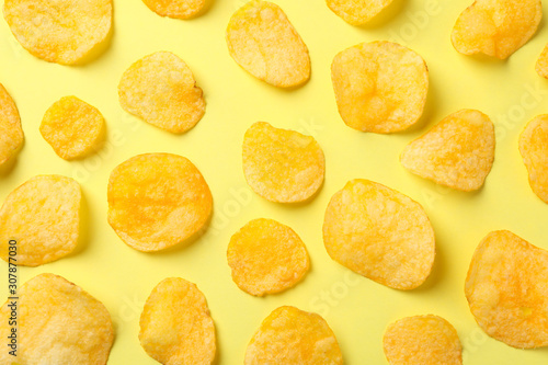 Flat lay composition with potato chips on yellow background, top view