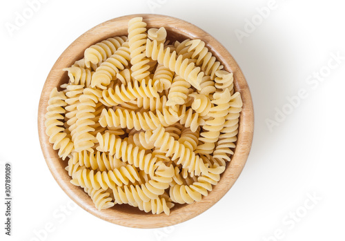 Uncooked fusilli pasta in wooden bowl isolated on white background with clipping path