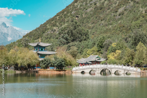 Beautiful view of the Jade Dragon Snow Mountain and the Suocui Bridge over the Black Dragon Pool in the Jade Spring Park, Lijiang,