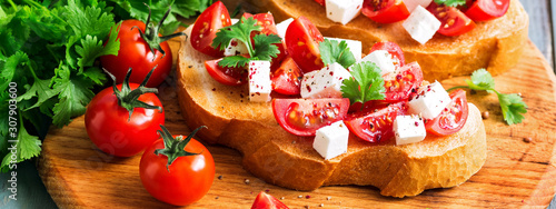Traditional Italian bruschetta with tomatoes, cheese and herbs, border.