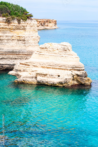 Torre Sant Andrea beach with its soft calcareous rocks and cliffs, sea stacks, small coves and the jagged coast landscape. Crystal clear water shape white stone create natural stacks. Melendugno Italy