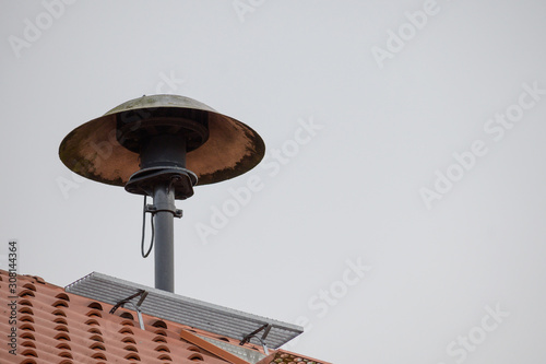 fire siren on a roof to alarm the fire fighter brigade in case of an emergency, gray sky with copy space