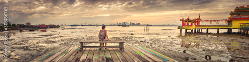 Tourist sitting at Yeoh jetty, Penang, Malaysia. Panorama