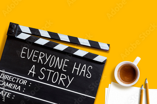 Everyone has a story.text title on movie clapper board and coffee cup on yellow background