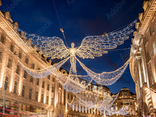 Big angel shape decorations outdoors on Regent Street illuminated by Christmas lights in winter holiday season in London, UK