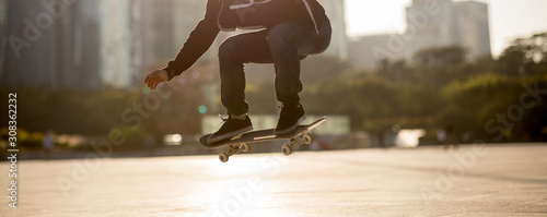 Skateboarder skateboarding at sunset city