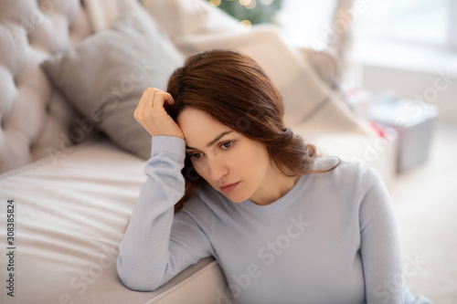 Pretty woman in grey homewear looking depressed