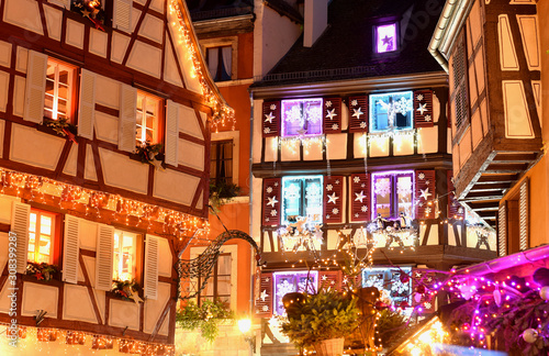 Colmar christmas decoration on streets and old houses. Holiday illumination on buildings.