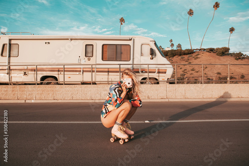 retro style skater girl with a camper van in the background. california lifestyle