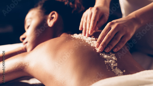 African-american woman having exfoliation treatment in spa