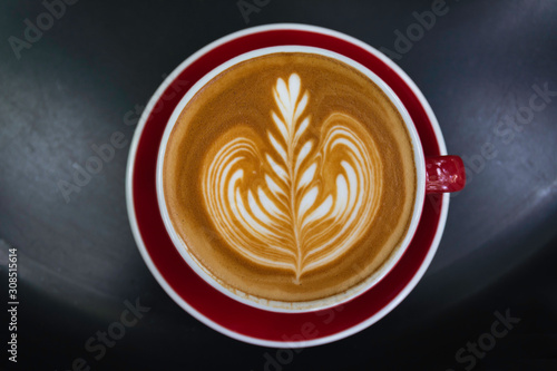 A cup of coffee on black table. Top view of coffee latte art. Drink and art concept.