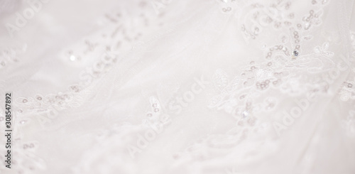White lace fabric with sequins, sequins. Delicate wedding background. Openwork