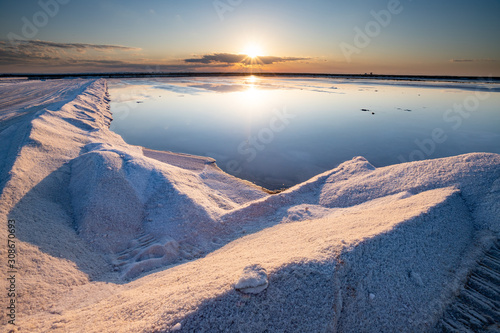 Nature reserve Saline Margherita di Savoia, Apulia, Italy: The salt pan. Salt flats area for sea salt production. A salt marsh, an ecosystem on Adriatic sea. Heaps of salt at sunset ready for harvest