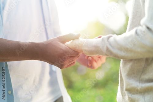 young asian couple holding hands outdoors