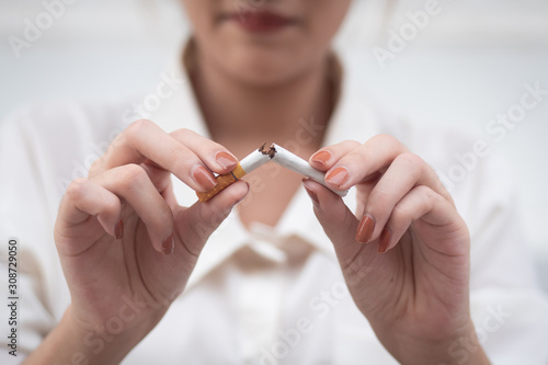 woman breaking cigarette to quit smoking; smoking ban or no smoking concept