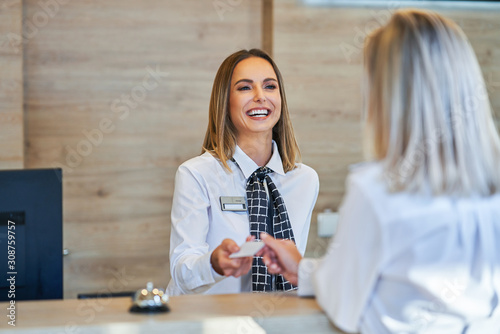 Receptionist and businesswoman at hotel front desk