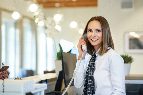 Receptionist answering phone at hotel front desk