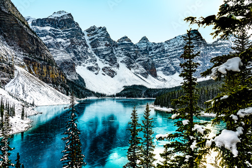 Moraine lake panorama in winter with frozen water and snow covered mountains, Banff National Park, Alberta, Canada