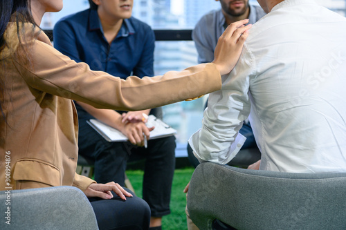 Psychotherapist inquiring about symptoms occurring within mind from patients with mental health problems in hospital. Group psychotherapy for support and helping worried man to change negative mindset