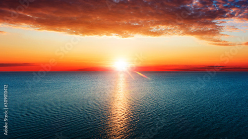 Aerial view of sun rising over sea.