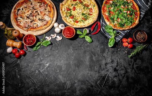 Traditional Italian pizza, vegetables, ingredients on a dark background. Top view with copy space. Pizza menu