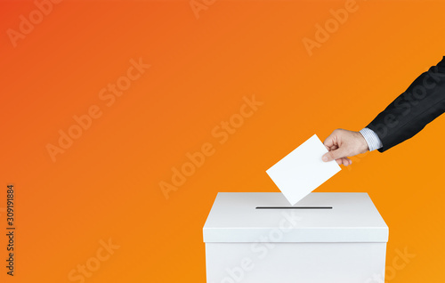 Hand of a person use a vote into the ballot box in elections. With orange background