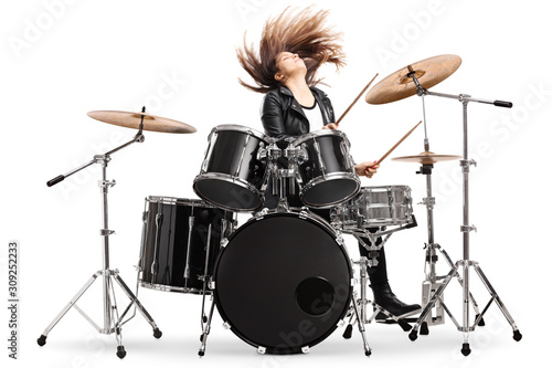 Energetic female drummer throwing her hair and playing drums