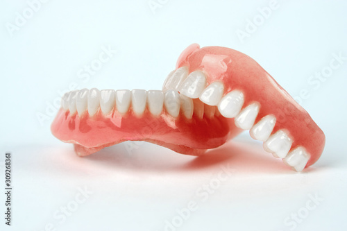 Diagnosis prosthetics treatment concept. Artificial teeth and magnifying glass