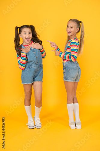 Best friends. Modern fashion. Kids fashion. Little girls wearing rainbow clothes. Happiness. Girls long hair. Cute children same outfits communicating. Trendy and fancy. Emotional kids. Fashion shop