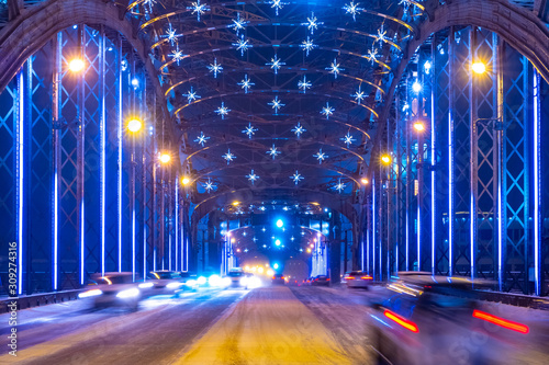 Saint Petersburg. Russia. Bolsheokhtinsky bridge in the new year. Peter the Great Bridge in Christmas lights. Cars ride on the night bridge. Lights of the night city. Christmas illumination