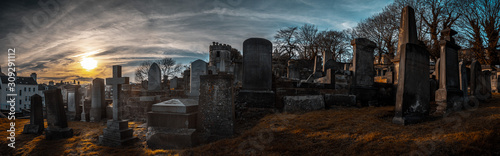 EDINBURGH, SCOTLAND DECEMBER 14, 2018: old, desolated and grungy tombstones, memorials and headstones in the graveyard with the sun rising at New Calton Burial Ground