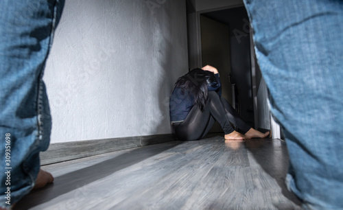 Femme battue assise dans un couloir
