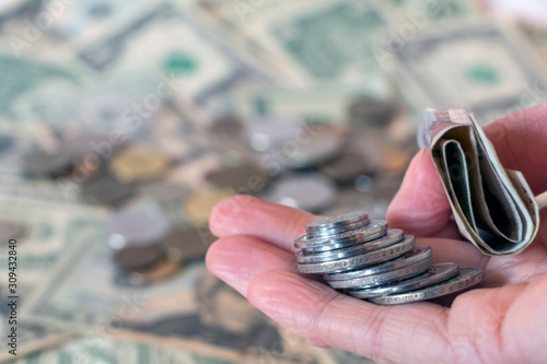 Hand holding georgian lari coins and banknotes against usd american dollar background with russian ruble rub coins