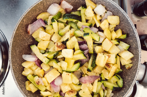 Zucchini, potatoes and onions stir-fried in a pan