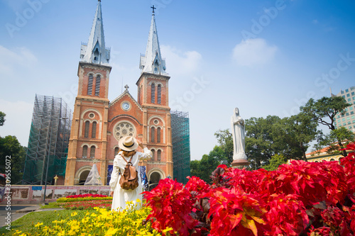 Woman tourist is sightseeing in front of Notre Dame Cathedral of Saigon in Hochiminh City in Vietnam.