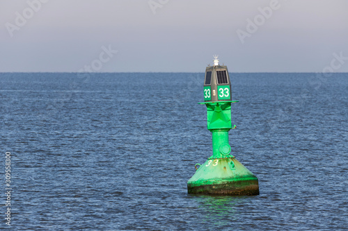 green lateral buoy at the edge of a fairway