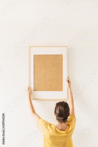 Woman hold blank photo frame with empty copy space on white background. Minimal artist work concept.