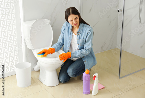 Young woman feeling disgust while cleaning