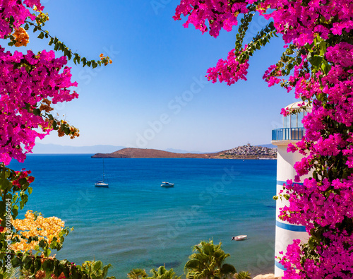 Beautiful pink and purple flowers frame a sea view in Ortakent, Bodrum, Turkey