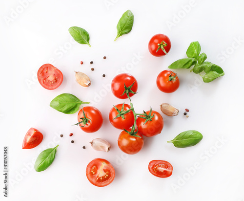 Ripe red cherry tomatos and basil on white background. Top view