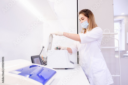 Charming young female scientist stacks analysis in a climate control chamber in a laboratory for further research. Concept of creating vaccines and new antiviral drugs. Healthcare and Genetic Research