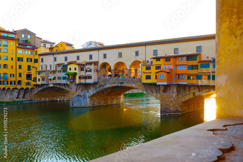 Beautiful landscape view of colorful Florence city with famous medieval stone bridge Ponte Vecchio and the Arno River at sunset light. Firenze scenery panorama, Italy Europe. Italian summer vacation.