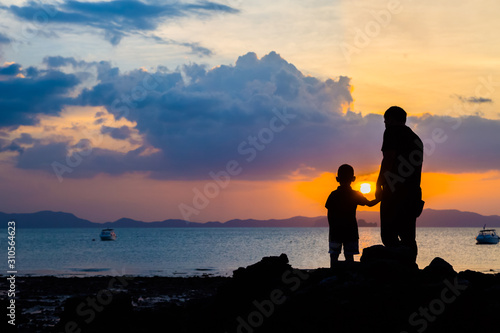 Sylwetka wizerunek ojciec i syn przy plażą