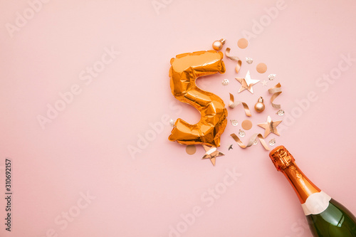 Happy 5th anniversary party. Champagne bottle with gold number balloon.