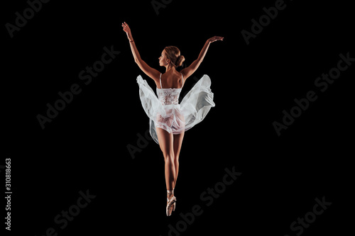 ballerina dancing in studio on a black background. dancer in motion with his back. isolated. young ballet dancer 