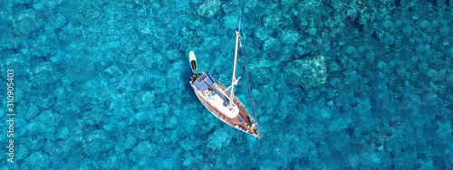 Aerial drone photo of luxury sail boat docked in tropical exotic bay with turquoise crystal clear sea